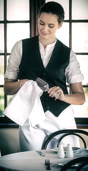 woman waitress polishing wine glass at an upscale fine dining restaurant